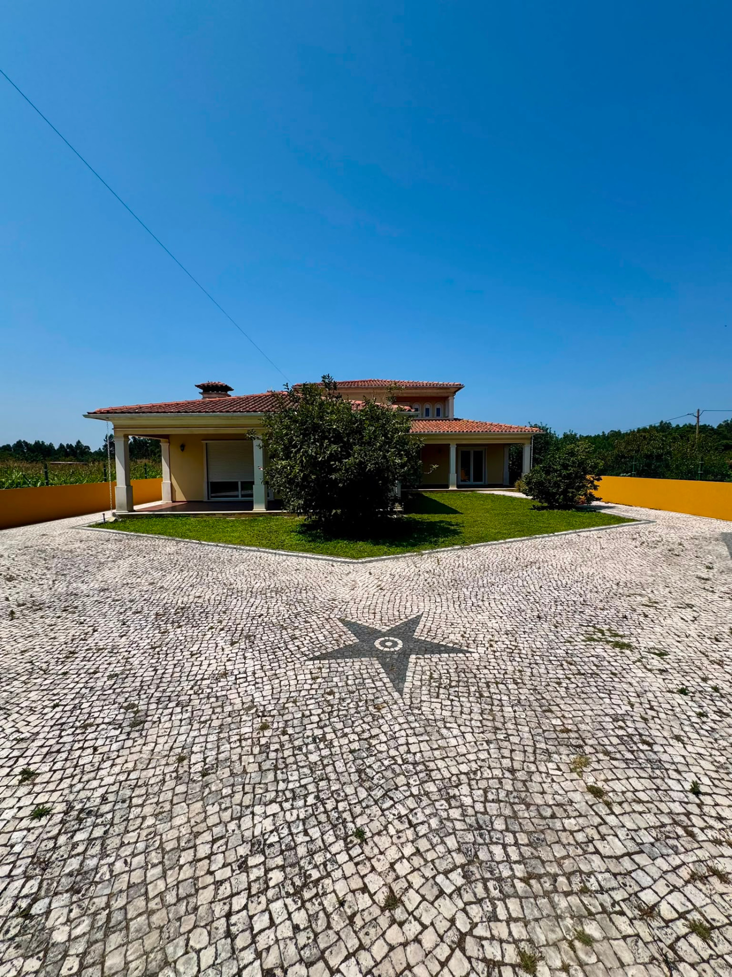 Fachada da West Gold em Mira — calçada portuguesa, alpendre e jardim